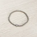 Close-up of a silver stainless steel beaded bracelet with a heart initial O charm. - Heart Initial O Style (YB-S1090-O) / Stretchy