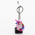 Detailansicht eines bunten Einhorn-Schlüsselanhängers aus weichem PVC auf einem Ständer - Rosa Gesicht Rote Schleife