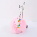Gros plan d'un porte-clés pompon rose avec charme licorne arc-en-ciel - Style Licorne Assise (06)