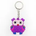 Detailed macro view of a cute purple soft PVC owl keychain with a metal split ring - Purple