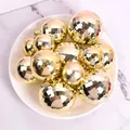 Collection of golden electroplated mirror disco balls on a white plate for party decor - Set of 12 / Gold