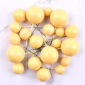 Collection of yellow macaron foam ball cake toppers scattered on marble surface - 20 Pieces Set / Yellow