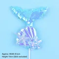 Detail view showing iridescent mermaid tail cake topper with sequins and blue starfish. - Blue