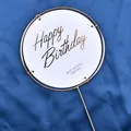Elegant gold foil Happy Birthday cake topper with a circular iron frame on blue background - Round White