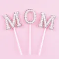Detailed view of the pearl and rhinestone MOM cake topper set on pink background - Pearl MOM Style / White