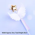 Detailed close-up of a white angel wings cake topper with a gold star and purple ribbon. - White Plastic Wings / White