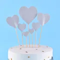 Close-up of silver glitter heart cake toppers on a white cake with gold flakes. - Heart / 7-Pack Set / Silver