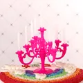 Close-up of mini magenta plastic candelabra with white candles on a cake - Rose Red (With Candles)