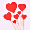 Detailed view of various red heart cake toppers on wooden sticks for romantic parties - Heart Shape / Plastic Stick Style / Red Glitter