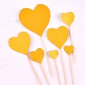 Detail view of seven golden glitter heart cake topper inserts for party dessert decorations - Heart Shape / Plastic Stick Style / Gold Glitter