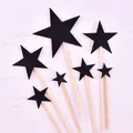 Close-up detail of black glitter star cake toppers on wooden sticks with a white background - Five-pointed Star / Plastic Stick Style / Black Glitter