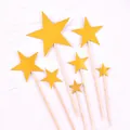Vue détaillée de sept décorations de gâteau en forme d'étoiles dorées à paillettes sur blanc - Étoile à Cinq Branches / Style de Tige en Plastique / Paillettes dorées