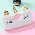Gros plan d'une trousse licorne en peluche blanche avec corne dorée et texture douce - Licorne / Blanc