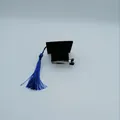 Close-up detail of mini black graduation cap hair clip with vibrant blue tassel accessory - Black Cap with Blue Tassel