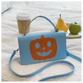 Close-up view of light blue Halloween crossbody bag featuring orange pumpkin patch - Blue