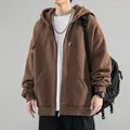 Detailed view of a brown oversized zip-up hoodie featuring a plastic zipper and pockets. - Coffee
