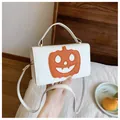 White Halloween pumpkin shoulder bag with cute orange face patch and adjustable strap. - White