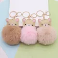 Detailansicht von drei süßen Kunstpelz-Bären-Pompon-Schlüsselanhängern in Pastellfarben - Goldene Kettenschließe / Mehrfarbig