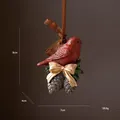 Vintage kerstornament van hars met rode vogel, een gouden strik en dennenappels - Dennenappel Vogel