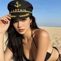 Classic black sailor captain hat with gold anchor embroidery worn by a model on a beach - Black Captain Hat