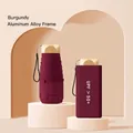 Elegant burgundy mini folding sun umbrella with UPF 50+ protection and matching case. - 6-Rib Black Glue UV Gold Handle / Burgundy