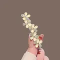 Elegant gold floral hair clip featuring cream flowers and shimmering rhinestone detail - Gold Rhinestone Cat Eye Flower Spring Clip