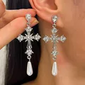 Dettaglio di orecchini a croce gotica decorati con strass e perla bianca pendente - Stile Croce con Strass a Stella Argento Antico con Perla a Goccia / Argento Antico (Goccia Bianca)