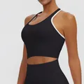 Detailed side view of a black sports bra featuring white trim and supportive padding. - S / Tops / Black with White Trim