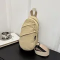 Detail view of the beige nylon chest bag with layered zippers and minimalist style. - Khaki