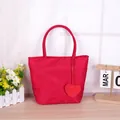 Vibrant red nylon tote handbag with heart charm for casual use or as a gift bag. - Handbag With Heart Pendant / Red