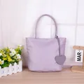 Stylish lavender purple tote bag with double top handles and cute heart charm detail - Handbag With Heart Pendant / Purple