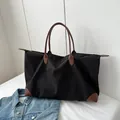 Large capacity black travel tote bag with brown faux leather handles and nylon fabric - Black