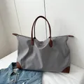 Large capacity grey nylon travel tote bag with brown leather handles and corner accents - Gray