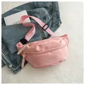 Minimalist pink nylon waist bag with a sporty design presented on top of a denim jacket - Pink