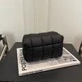 Stylish black quilted puffer cosmetic bag featuring a grid pattern and zipper closure - Black