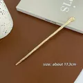 Macro detail of minimalist gold-finish hair stick with 17.3cm length measurement - Straight Texture Style / Gold