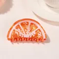 Dettaglio ravvicinato di una pinza per capelli a forma di fetta d'arancia trasparente - Stile Arancia / Arancione