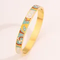 Close-up of colorful enamel drip oil pattern on a gold stainless steel bangle for women. - Celadon Pattern Gold Bangle