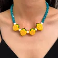 Vibrant yellow lemon fruit charm necklace with blue and white beads worn by a model - Lemon Beaded Necklace (6680)