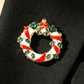 Christmas wreath brooch with red enamel and golden bells on black fabric background - Christmas Wreath