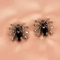 Nahaufnahme von gotischen Spinne Ohrsteckern mit schwarzen Strasssteinen auf rosa Satin - Legierung Spinne Ohrstecker (1048) / Schwarz