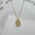 Gros plan d'un élégant pendentif ovale en pierre naturelle avec zircon au centre. - Collier en Zircone Ovale Topaze (250730320700) / Pendentif avec Chaîne / Jaune