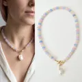 Gedetailleerde weergave van een regenboog kralenketting met barokke parelhanger. - Dromerige roze blauw groene parel (43cm)