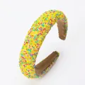 Gros plan d'un bandeau large coloré dopamine avec des perles colorées décoratives - Style Granulés Rembourrés / Jaune