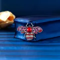 Vintage style bee brooch featuring vibrant red and pink crystals on blue jewelry box - Antique Silver Red Bee (XD10984-1)