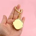Oval gold metal folding mini makeup mirror keychain in hand - Oval / Gold
