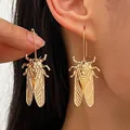 Detailed gold-toned cicada beetle dangle earrings displayed on model's ear and hand - Cicada Shape Ear Hook (7838) / KC Gold
