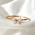 Eleganter goldener verstellbarer Ring mit Zirkon-Schleife auf weißem Satin-Hintergrund. - Einstellbar Offen / Rosa Schmetterlingsschleifen-Stil (JZ089)