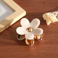 Nahaufnahme einer kleinen, perlweißen Haarspange mit Blume und eleganten Goldakzenten - Meerjungfrau-Farbe