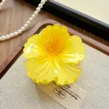 Detailed close-up of a yellow gradient flower-shaped hair claw clip on linen with pearls - Camellia / 8cm / Yellow